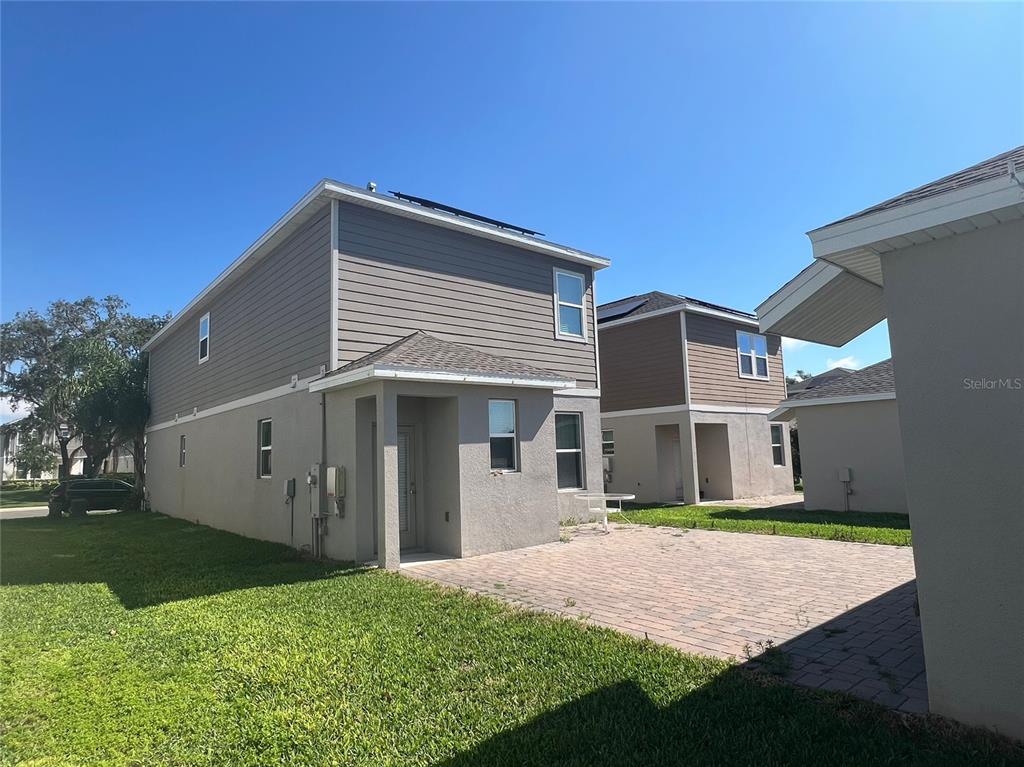 The exterior of a two-story house features gray siding, a stucco ground floor, and a patio — 17016 QUICKSILVER AVENUE, WINTER GARDEN, FL