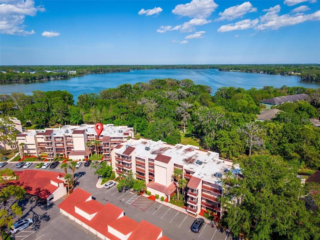 An aerial view shows a multi-story residential building with a red tile roof and balconies — 1162 CARMEL CIRCLE UNIT 440, CASSELBERRY, FL