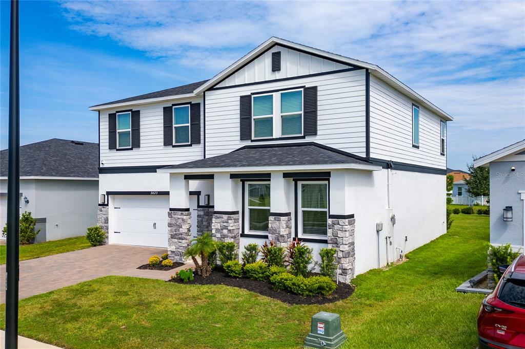 A two-story house with white siding, stone accents, and a two-car garage — 3023 SANCTUARY DRIVE, CLERMONT, FL