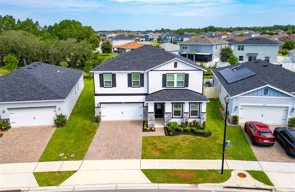 An aerial view of a two-story suburban house with a white exterior and stone accents — 3023 SANCTUARY DRIVE, CLERMONT, FL