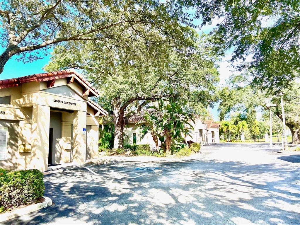 Exterior view of a tan commercial building with a tile roof and parking lot — 1550 W CLEVELAND STREET UNIT 11, TAMPA, FL