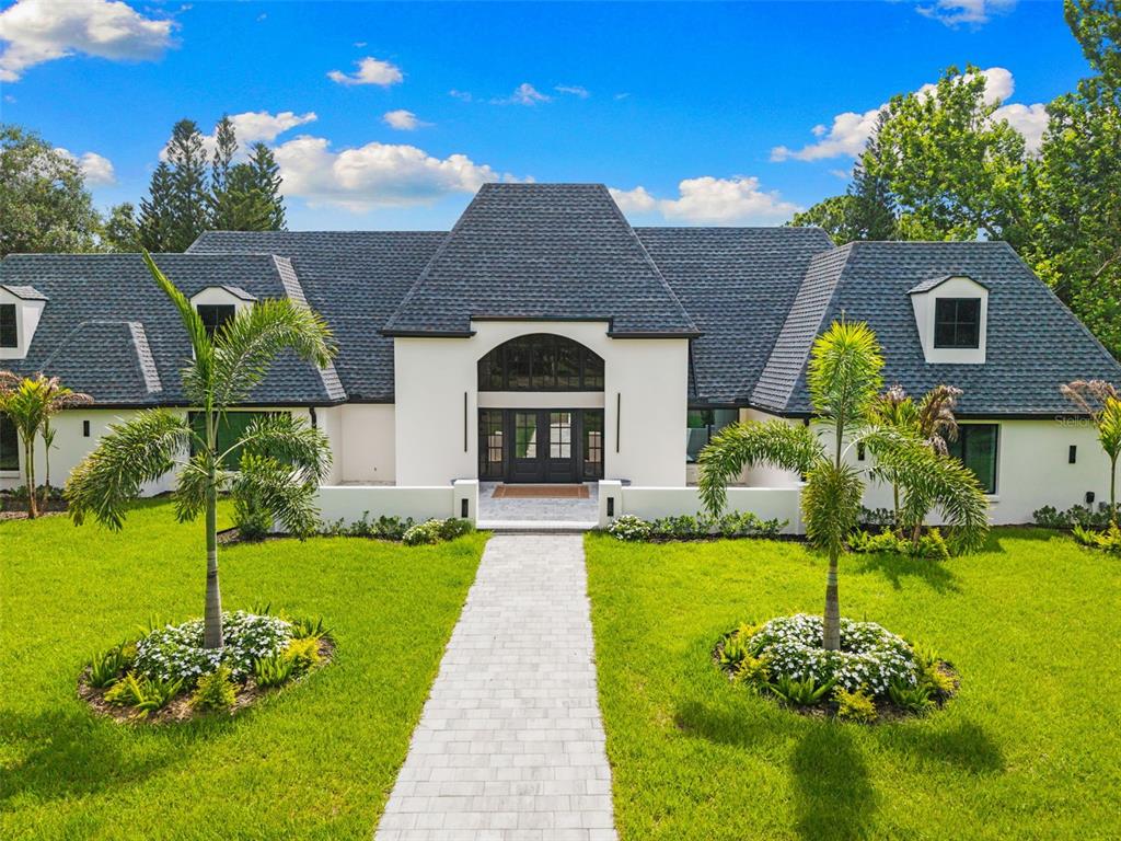 An aerial view shows a white two-story house with a dark shingled roof and dormers — 7351 IGUANA DRIVE, SARASOTA, FL