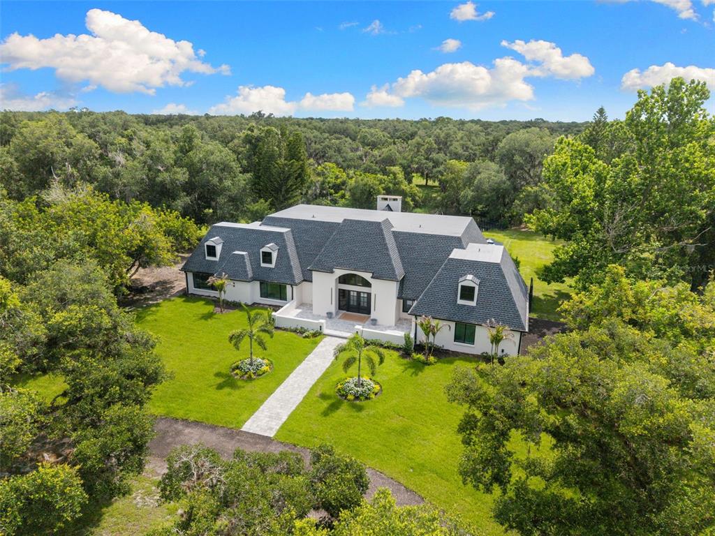 An aerial view of a white two-story house with a pool and patio area — 7351 IGUANA DRIVE, SARASOTA, FL