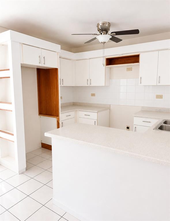A kitchen features white cabinets, a peninsula countertop, tiled flooring, and a ceiling fan — 518 CALLE WITO MORALES ESTANCIAS DEL GOLF CLUB, PONCE, PR