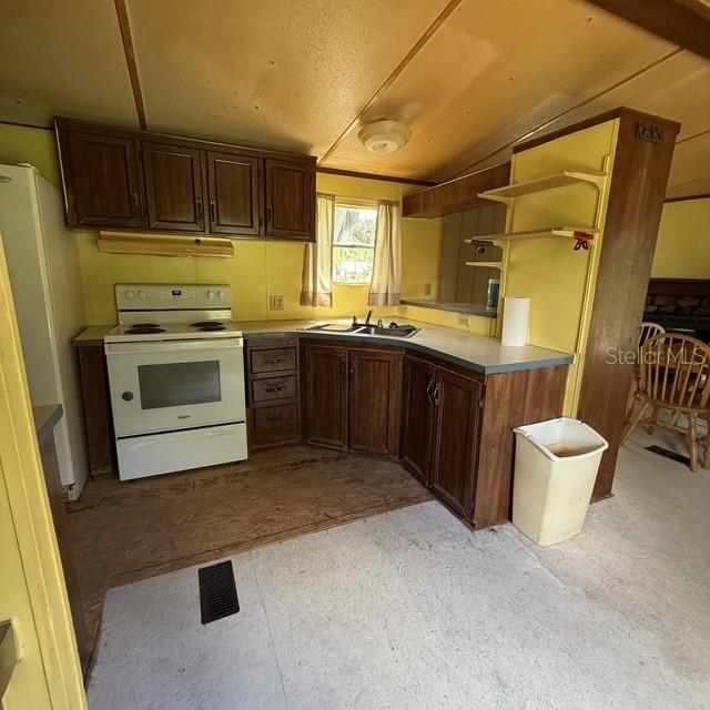 An empty room features yellow paneled walls, a window with a green blind, and subflooring — 45600 PANTHER STREET, PAISLEY, FL