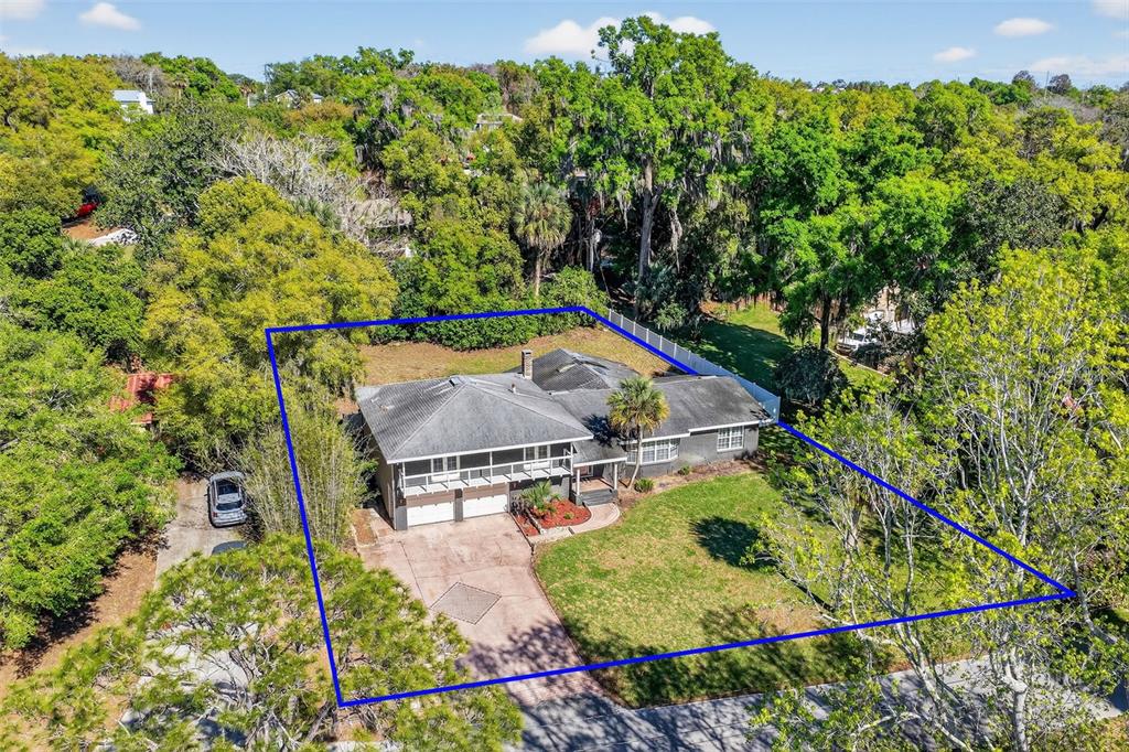 An aerial view shows a gray house with a two-car garage and a large yard — 1039 LAKE GRACIE DRIVE, EUSTIS, FL