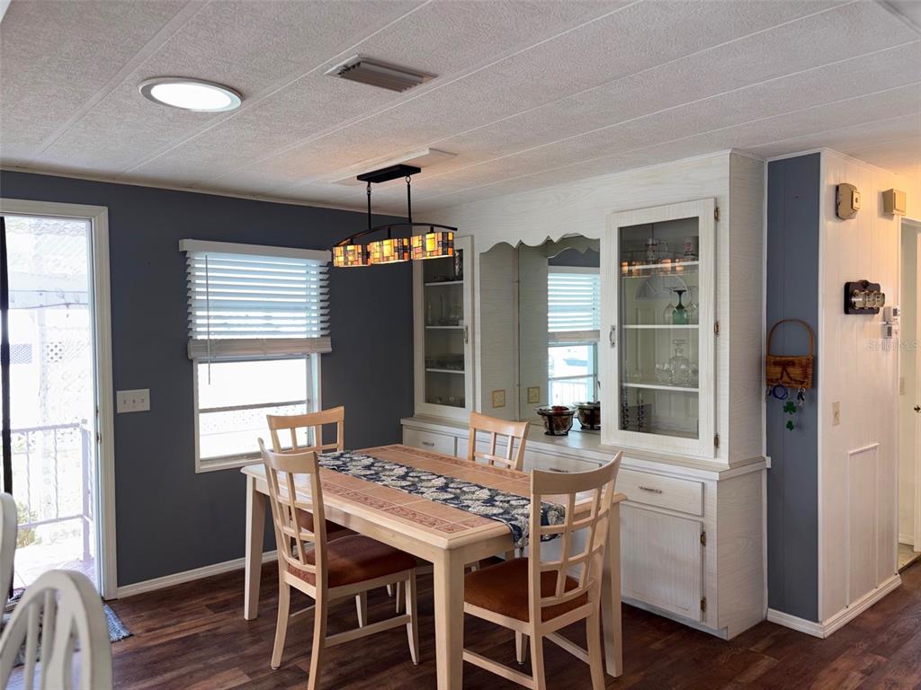 A dining area features a wooden table, four chairs, and a built-in white hutch — 413 CERVINA DRIVE N, VENICE, FL