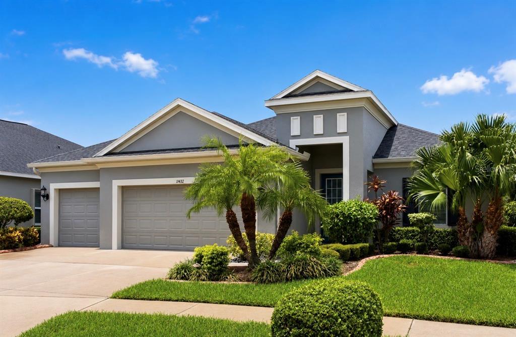 A gray single-story house with a two-car garage and a palm tree in front — 11432 DRIFTING LEAF DRIVE, RIVERVIEW, FL