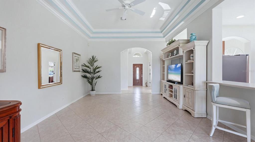 A living room features tile flooring, a white entertainment center, and a ceiling fan — 3337 PINE SHADOW CIRCLE, NORTH PORT, FL