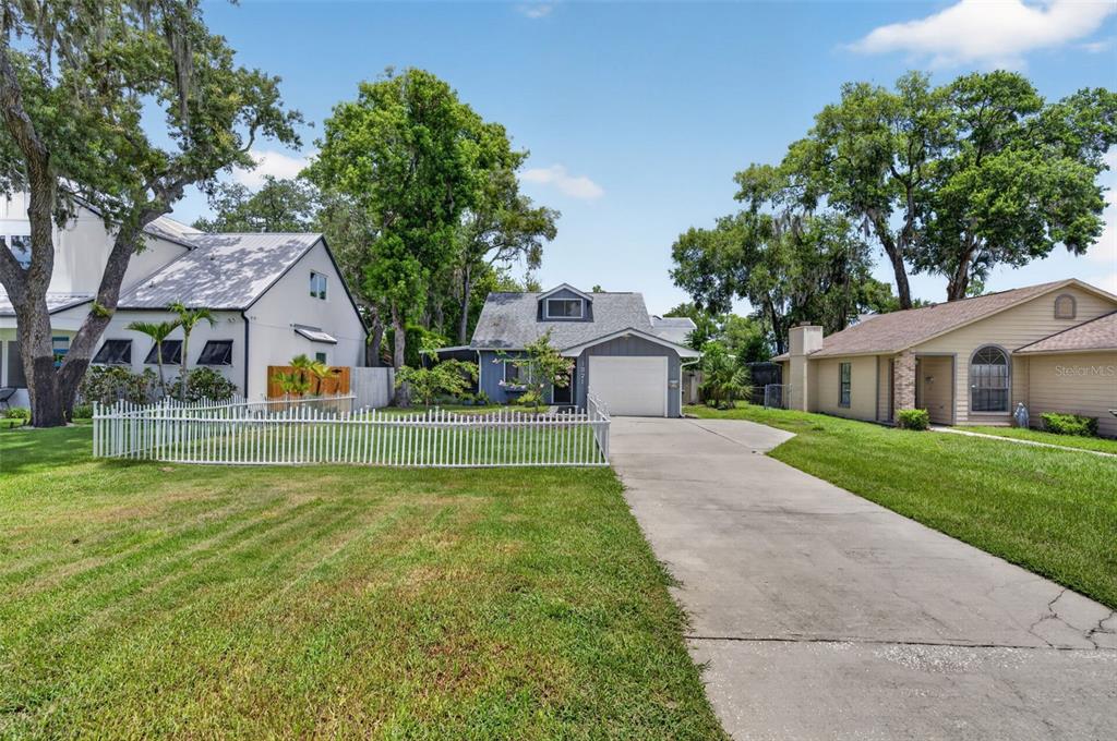A gray house with a white garage door sits between two other homes on a lawn — 1871 BRYAN AVENUE, WINTER PARK, FL