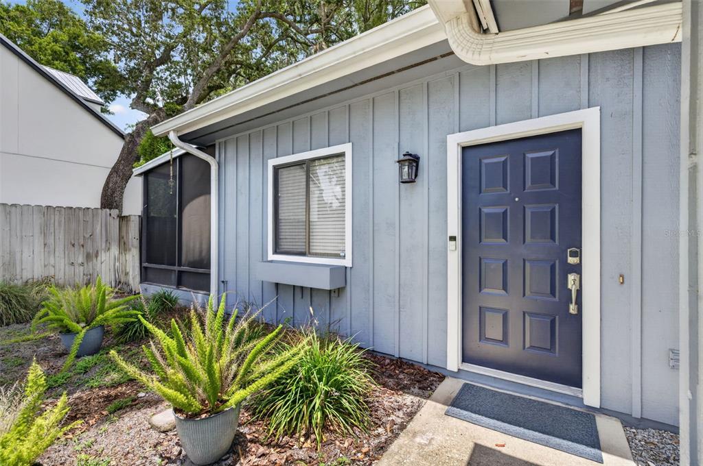 The exterior of a house features blue vertical siding, a dark blue front door, and plants — 1871 BRYAN AVENUE, WINTER PARK, FL