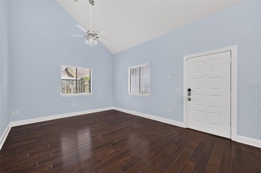 An empty room with light blue walls, dark wood flooring, a ceiling fan, and windows — 1871 BRYAN AVENUE, WINTER PARK, FL