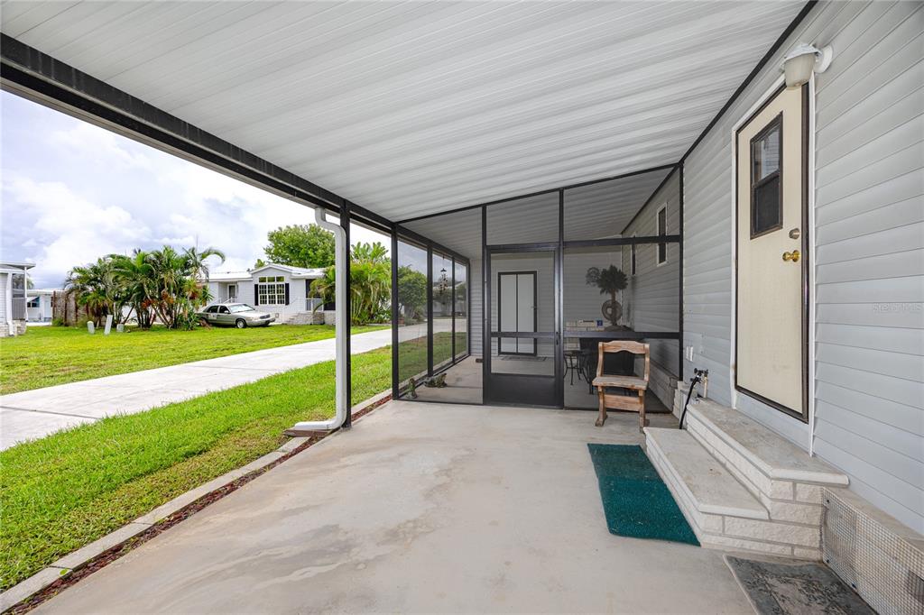 The exterior of a white mobile home features metal awnings and a concrete block foundation — 6821 AMERICANA DRIVE NE UNIT 106, ST PETERSBURG, FL