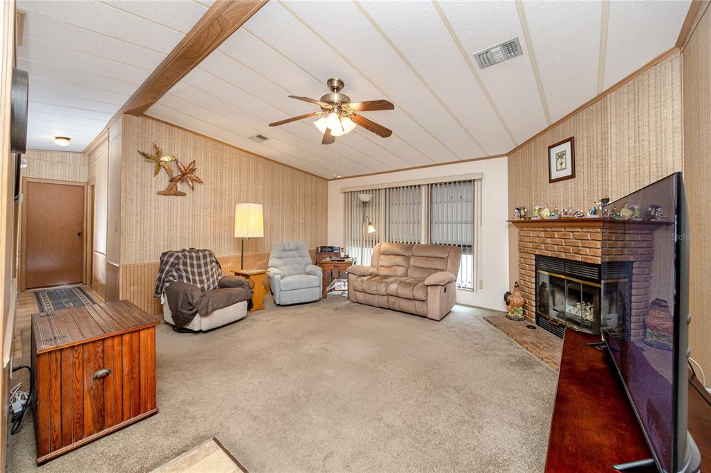 The exterior of a white mobile home features metal window awnings and a small garden — 6821 AMERICANA DRIVE NE UNIT 106, ST PETERSBURG, FL
