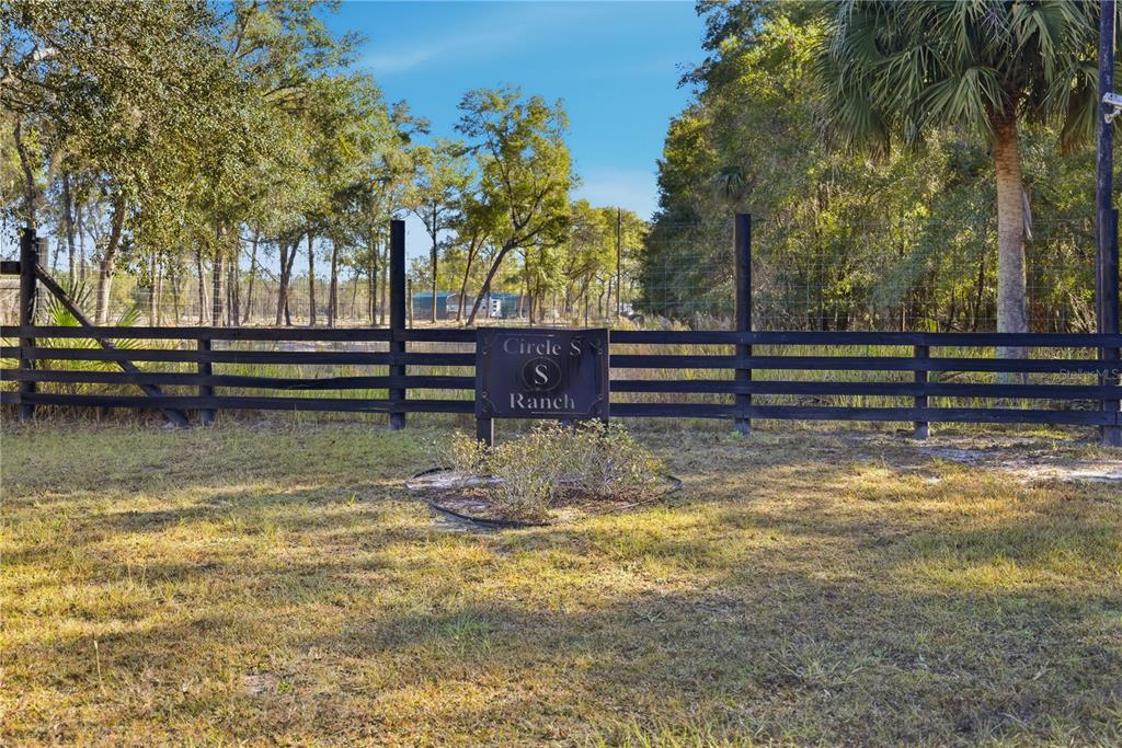 A black wooden fence surrounds a grassy field with a Circle S Ranch sign — TBD (Lot 2) NE 115TH LANE ROAD, FORT MC COY, FL