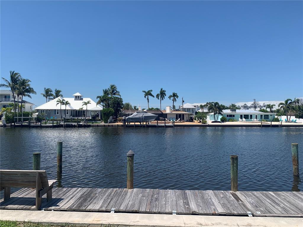 A wooden dock overlooks a canal with several waterfront houses and palm trees — 538 67TH STREET, HOLMES BEACH, FL
