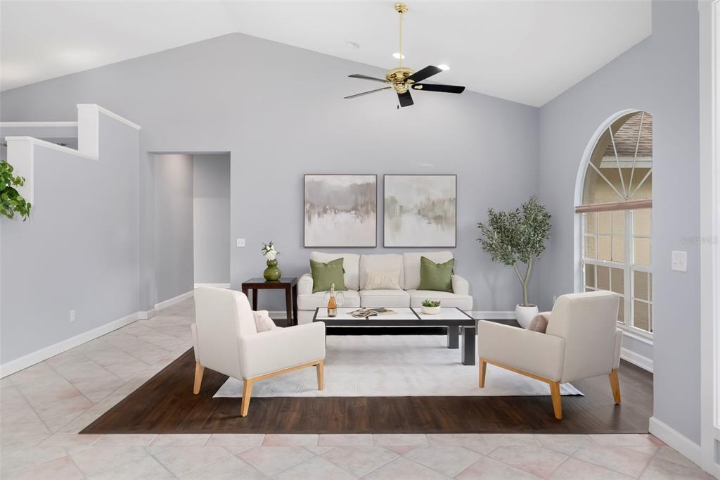 A living room features a vaulted ceiling, a ceiling fan, and a seating area arrangement — 296 PINE RANCH TRAIL, OSPREY, FL