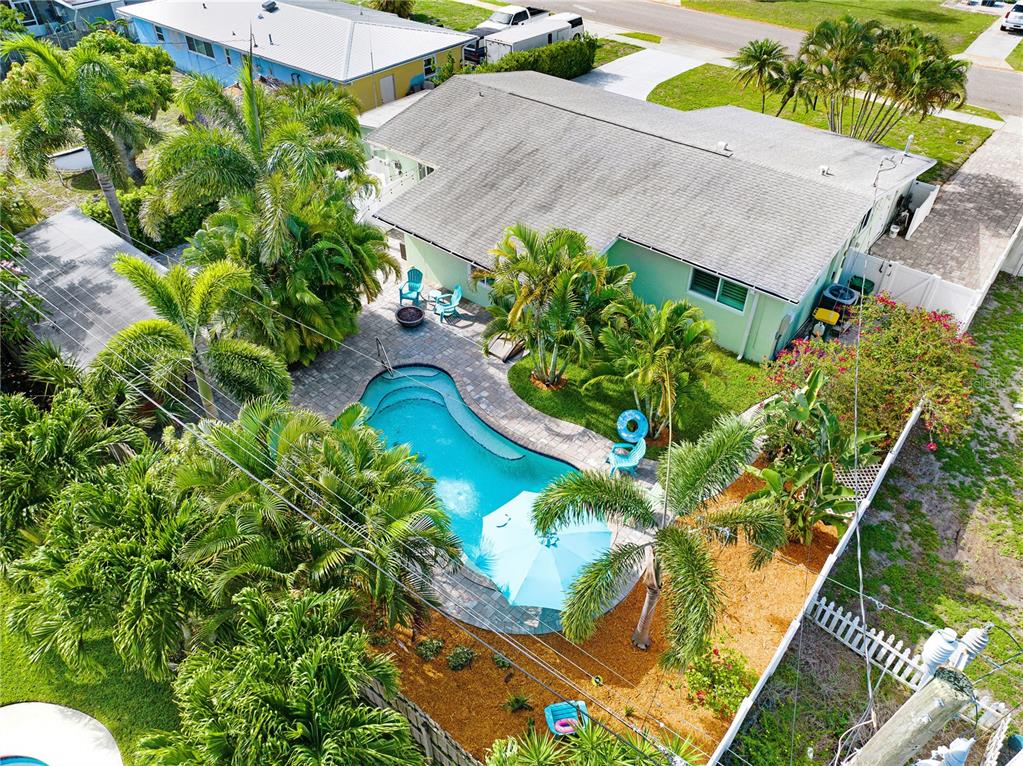 An aerial view shows a house with a backyard pool, patio, and surrounding palm trees — 231 OCEAN BOULEVARD, SATELLITE BEACH, FL