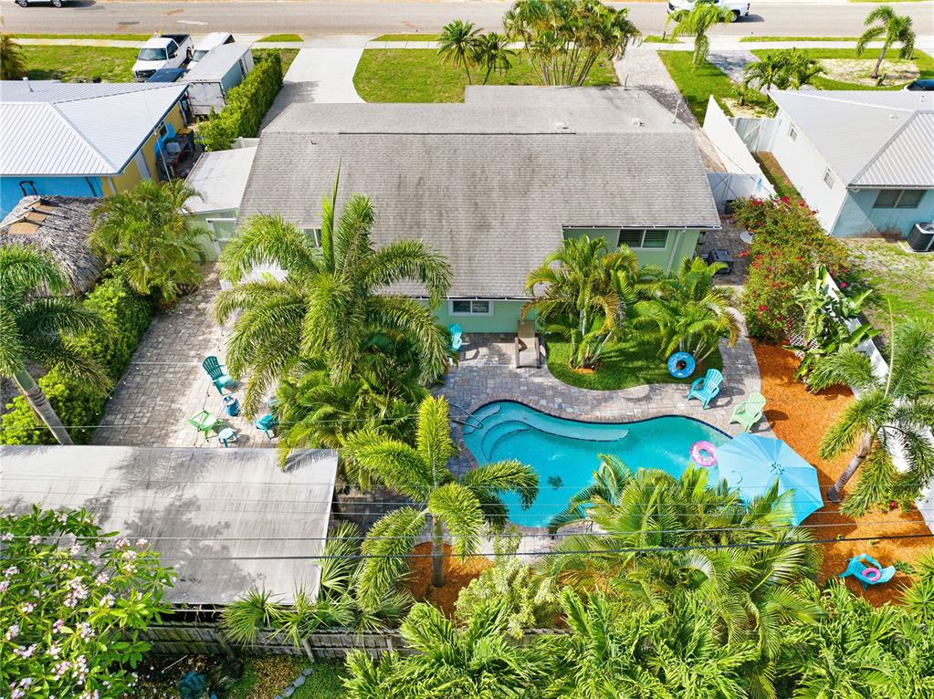 An aerial view shows a house with a backyard pool, patio, and palm trees — 231 OCEAN BOULEVARD, SATELLITE BEACH, FL