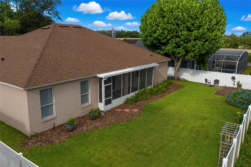 An aerial view of a house backyard featuring a screened-in porch and a grassy lawn — 3307 ROYAL ASCOT RUN, GOTHA, FL