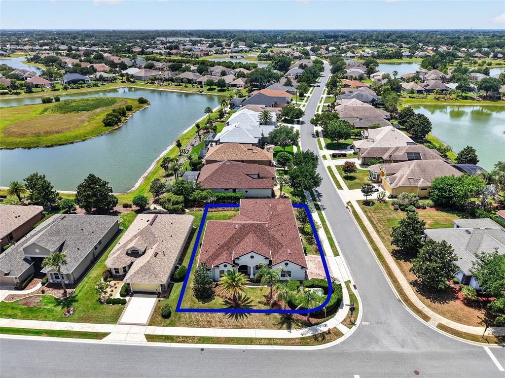 An aerial view shows a single-story house with a brown roof on a corner lot — 8237 BRIDGEPORT BAY CIRCLE, MOUNT DORA, FL