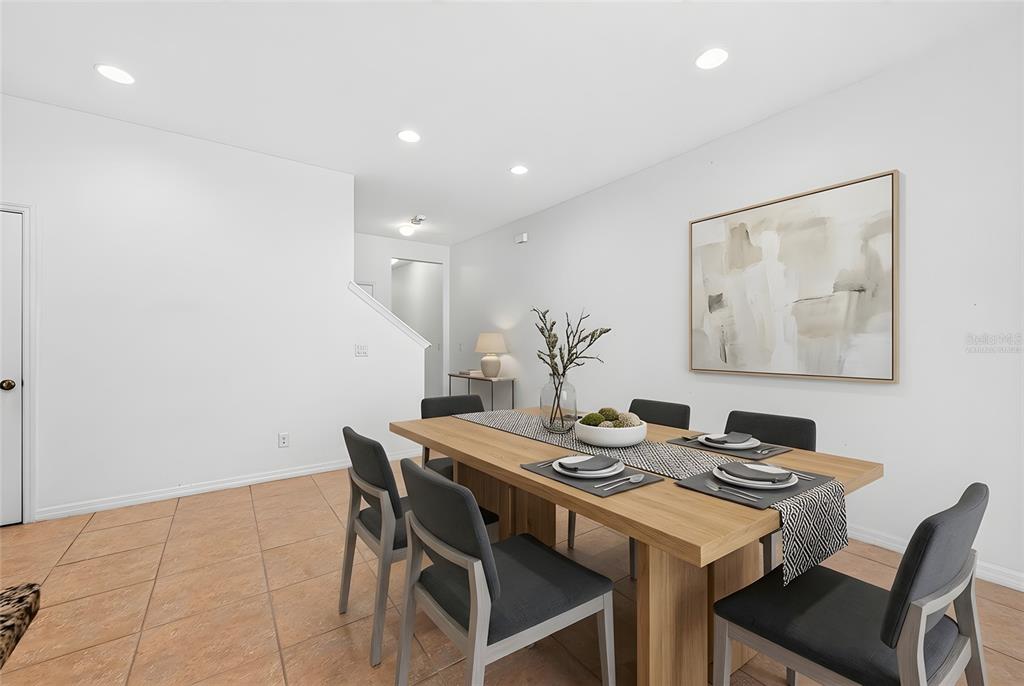 A dining room features a wooden table with six chairs, tile flooring, and wall art — 11429 BROWNSTONE STREET, WINDERMERE, FL