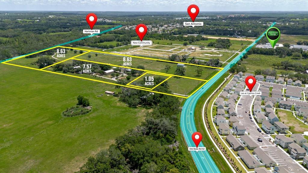 This aerial map shows several parcels of land outlined in yellow near a residential community — 31557 CR-52, SAN ANTONIO, FL