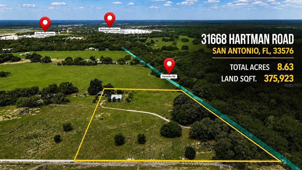 An aerial view shows a large, grassy plot of land outlined in yellow with a house — 31557 CR-52, SAN ANTONIO, FL