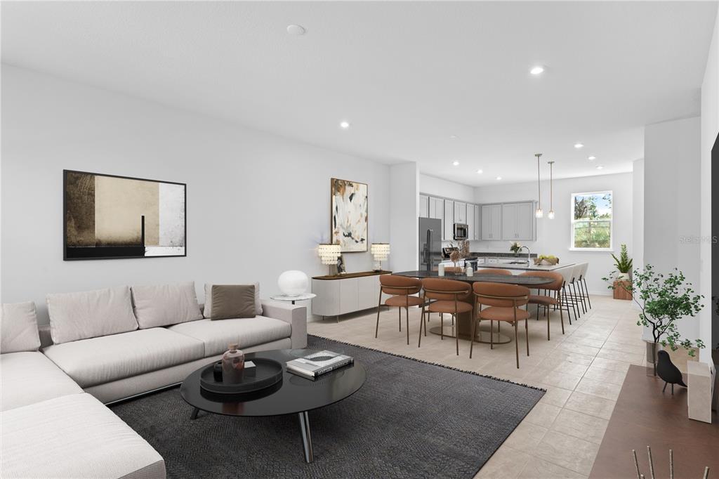 An open-concept living room and kitchen featuring a sectional sofa, dining table, and light cabinetry — 9610 MONTAGUE STREET, WESTCHASE, FL