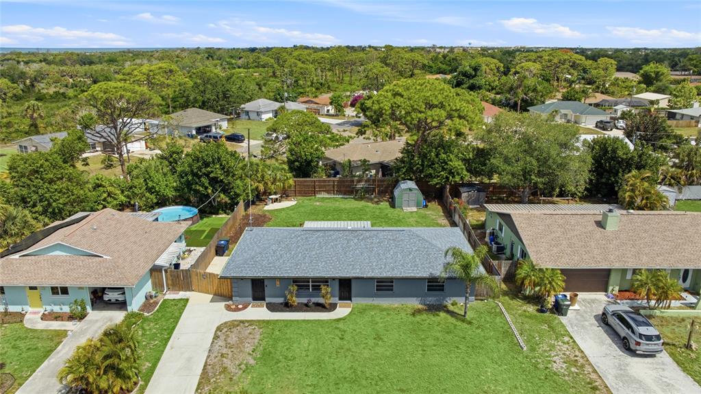 An aerial view shows a single-story gray house with a large front lawn and backyard — 3670 SUNSET BEACH DRIVE, VENICE, FL