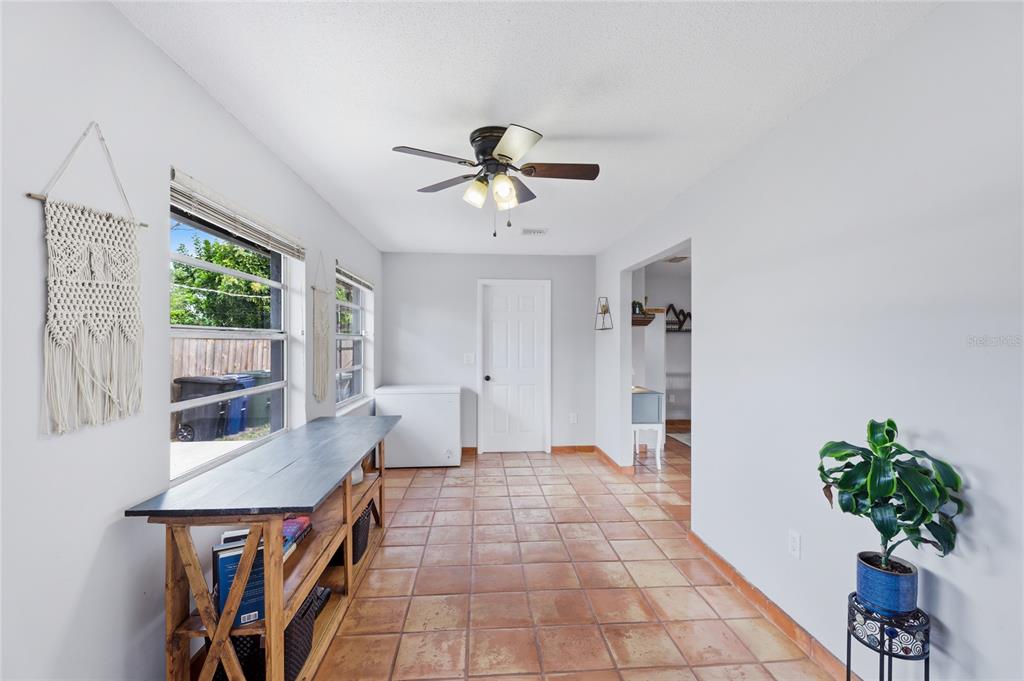 A room with tile flooring, a ceiling fan, a long wooden table, and a freezer — 3670 SUNSET BEACH DRIVE, VENICE, FL