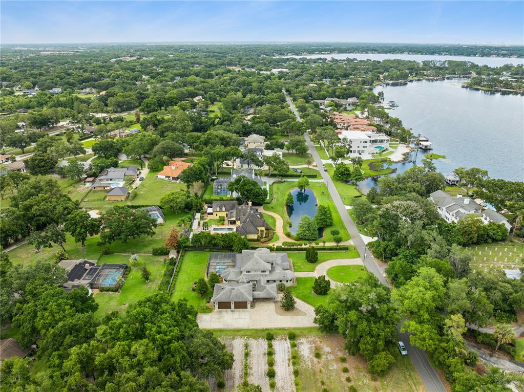 A living room features a large sectional sofa, built-in shelving, and sliding glass doors to a pool — 11539 LAKE BUTLER BOULEVARD, WINDERMERE, FL