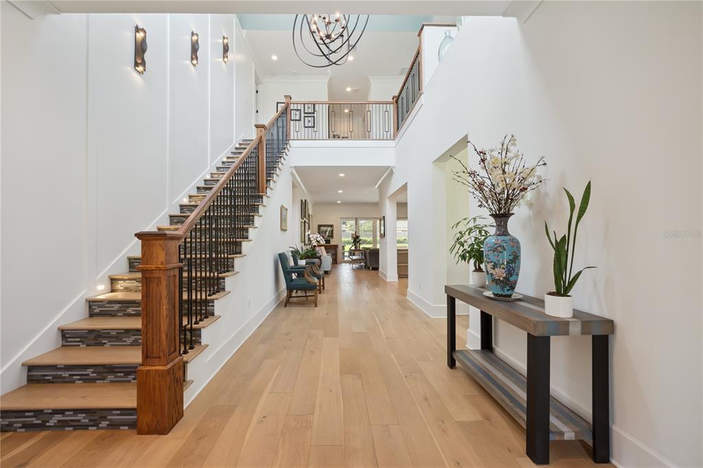 An open-concept kitchen and living area features white cabinetry, a large island, and gray furniture — 11539 LAKE BUTLER BOULEVARD, WINDERMERE, FL