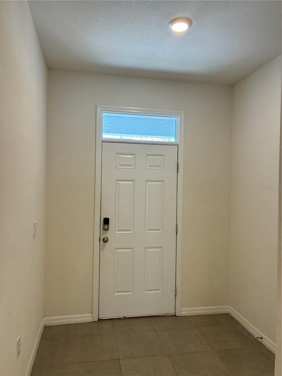 An entryway features a white six-panel door with a transom window and tiled flooring — 2913 BELUGA BAY DRIVE, ODESSA, FL