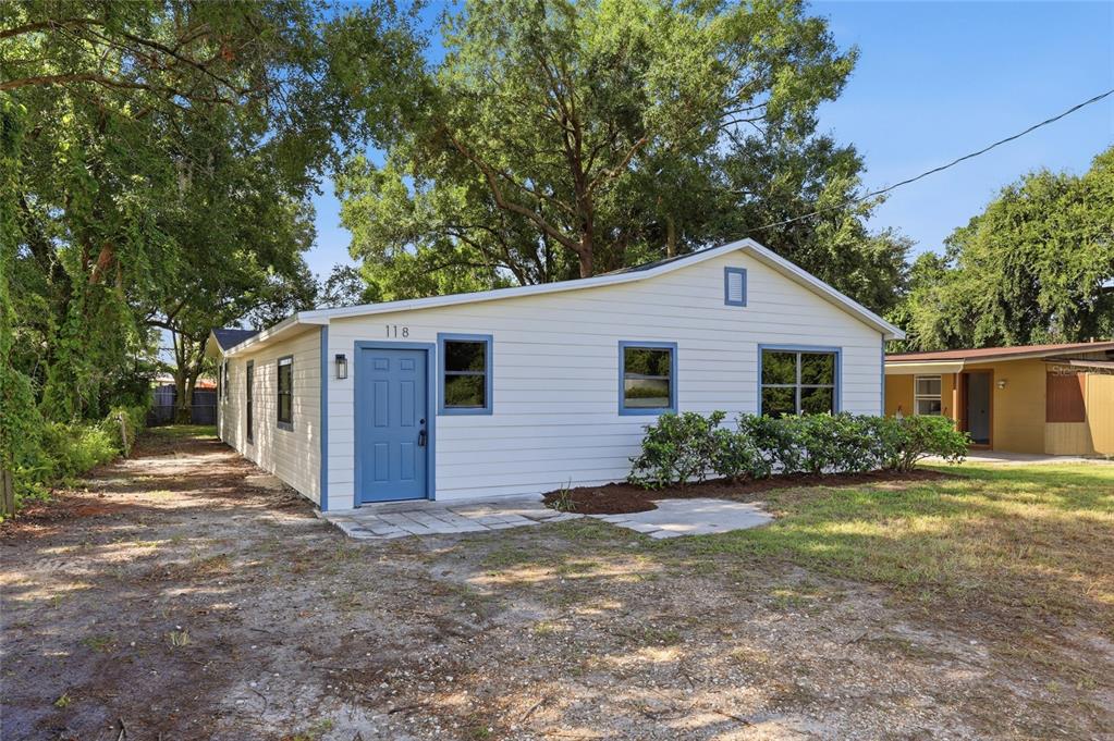 A single-story house with white siding, blue trim, and a blue front door — 118 COURT STREET, KISSIMMEE, FL