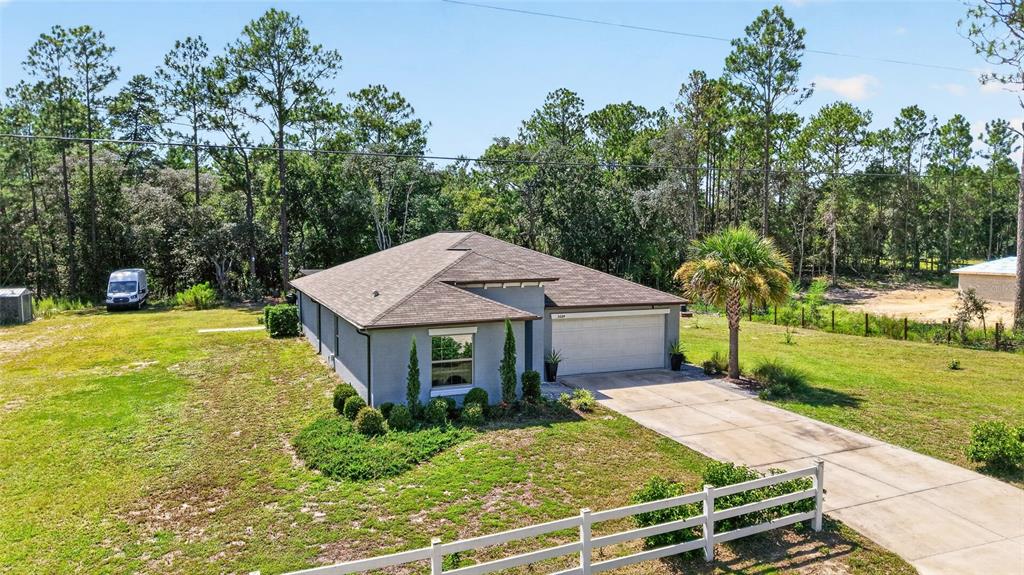 A single-story house with a gray exterior, a two-car garage, and a white fence — 5684 SW 136TH AVENUE, OCALA, FL