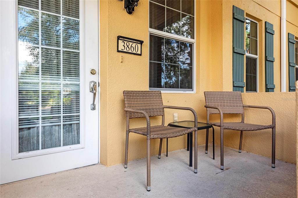 A front porch features two wicker chairs, a small table, and a white door — 3860 82ND AVENUE CIRCLE E UNIT 101, SARASOTA, FL