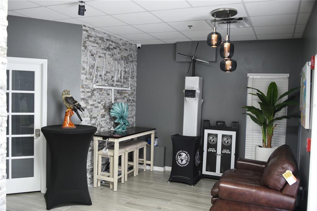 A modern office waiting area features gray walls, a stone accent wall, and leather seating — 418 S TAMIAMI TRAIL UNIT E3, OSPREY, FL