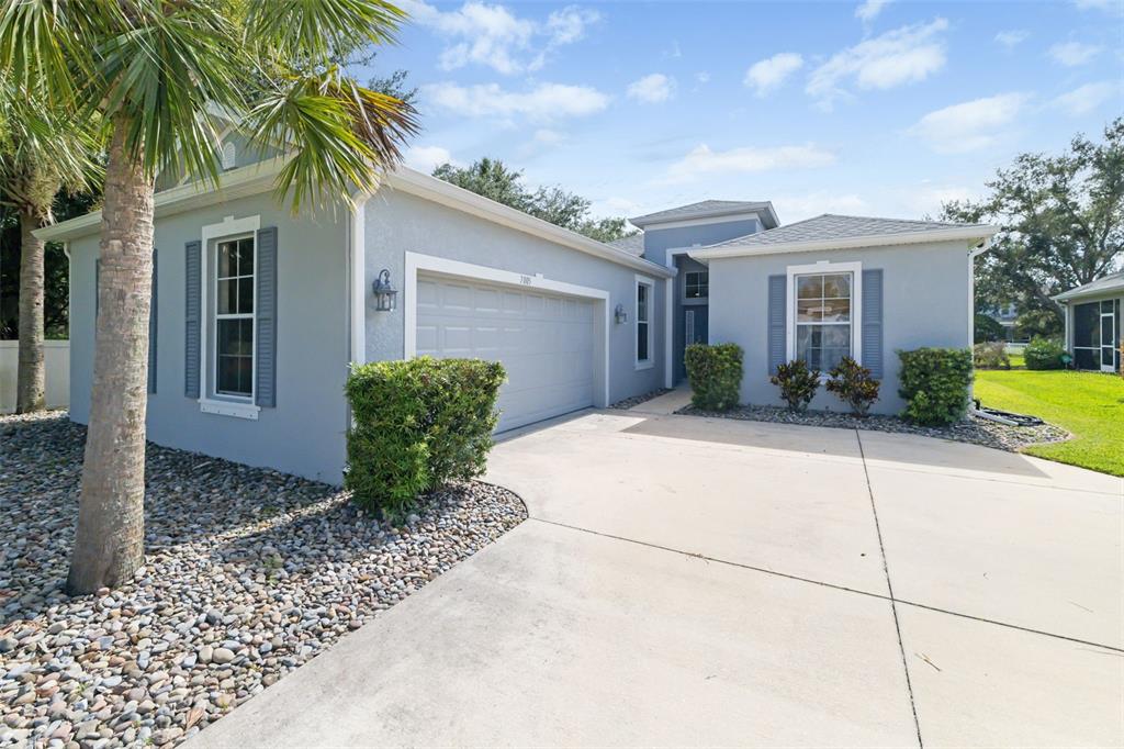 A light blue single-story house with a two-car garage and a concrete driveway — 7005 56TH TERRACE E, PALMETTO, FL