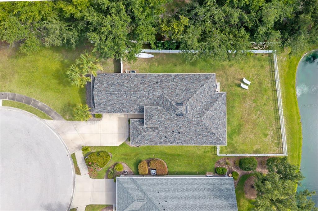 An aerial view shows a single-story house with a shingled roof, driveway, and fenced backyard — 7005 56TH TERRACE E, PALMETTO, FL