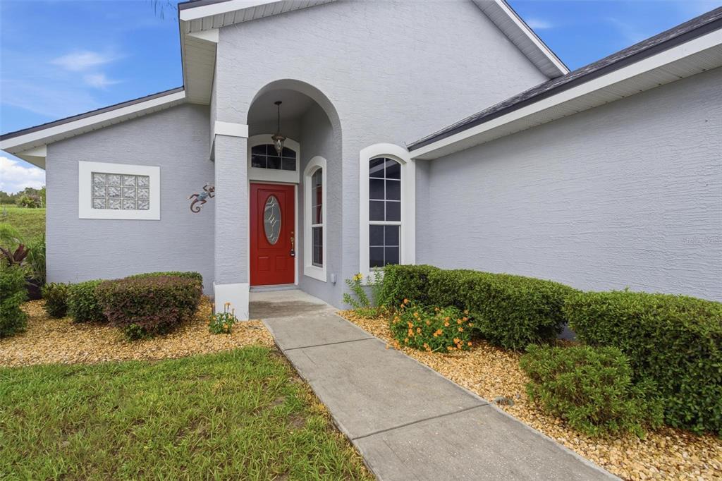 A detached garage with a concrete driveway and a large tree in the front yard — 93 FAIRWAY CIRCLE, UMATILLA, FL