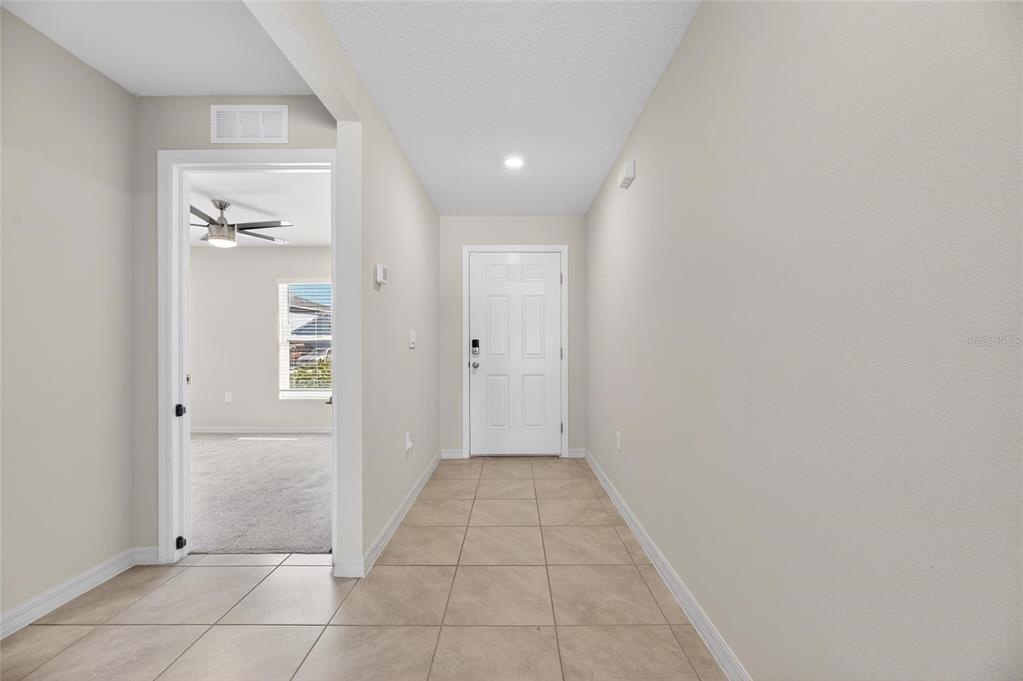 A tiled entryway leads to a white front door with a room visible to the left — 1324 OCEAN SPRAY DRIVE, RUSKIN, FL