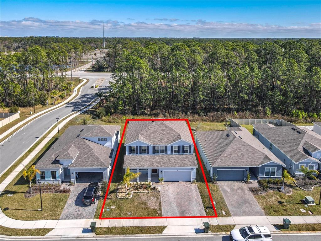 An aerial view shows a two-story suburban house outlined in red with a paved driveway — 121 EAGLE HARBOR WAY, DAYTONA BEACH, FL