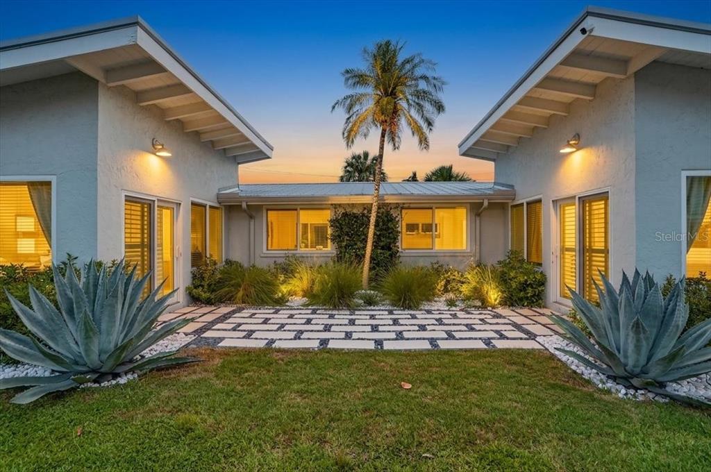A courtyard with a stone paver path sits between two wings of a house — 6203 HOLMES BOULEVARD, HOLMES BEACH, FL