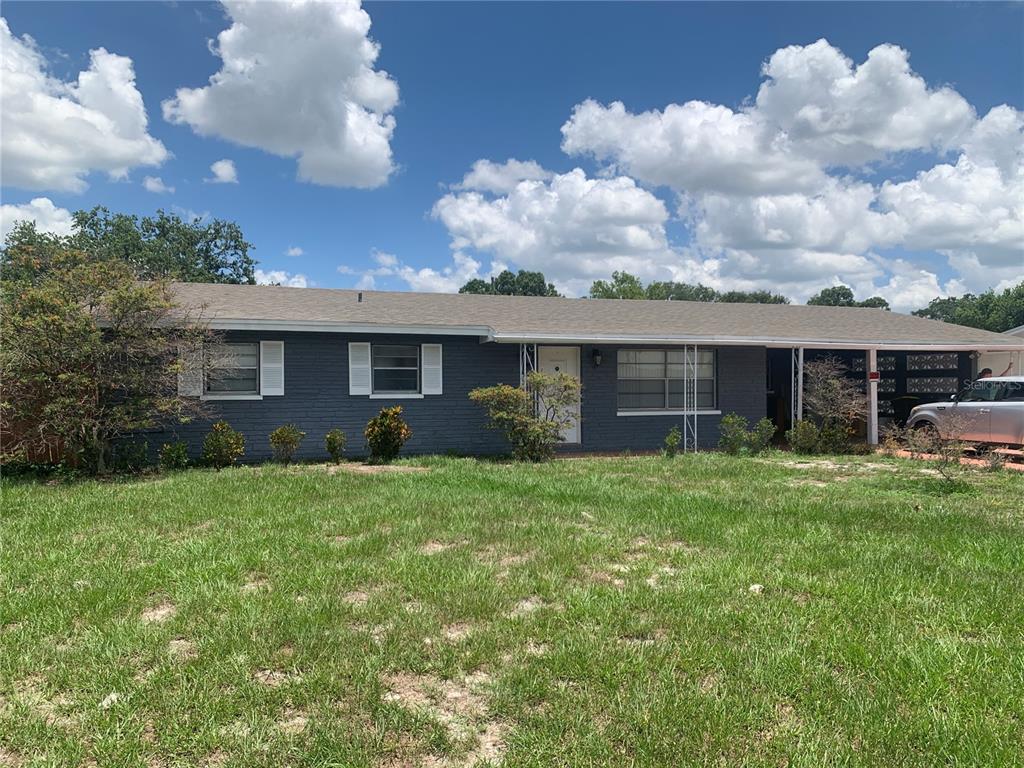 A single-story house with dark gray brick siding, a light-colored roof, and a front carport — 119 ALLEN AVENUE, WINTER HAVEN, FL