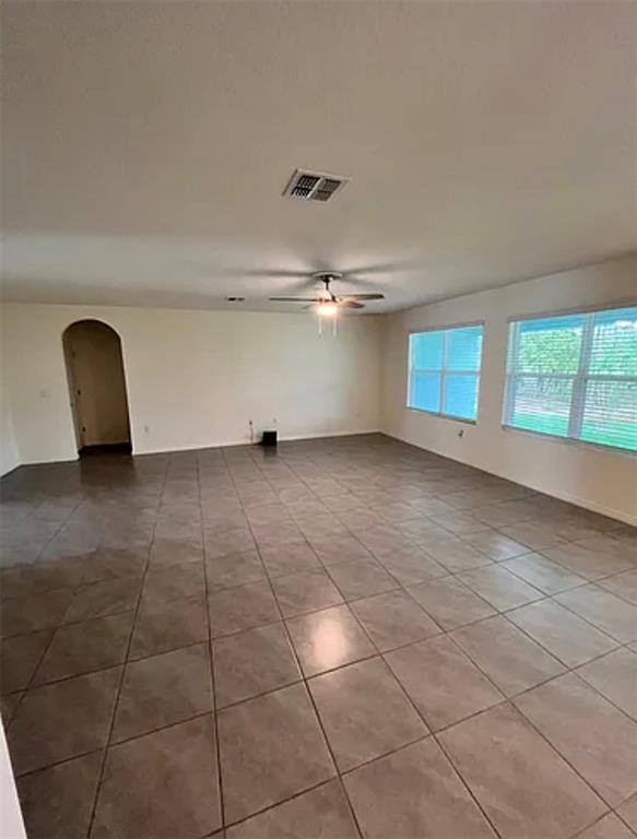 An empty living room features large square floor tiles, a ceiling fan, and two windows — 5 HICKORY COURSE LOOP, OCALA, FL