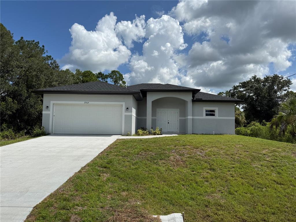 A single-story house with a white garage, gray exterior walls, and a concrete driveway — 2964 WELLS AVENUE, NORTH PORT, FL