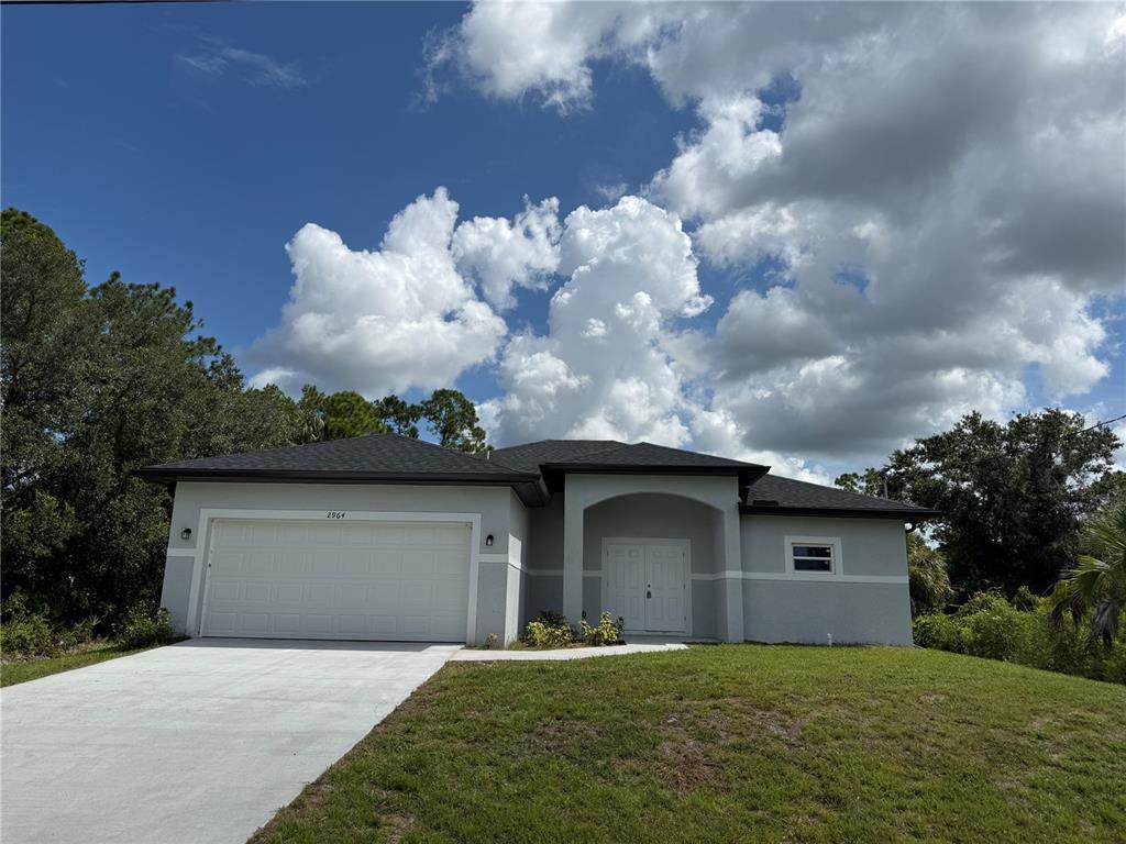 A single-story house with a gray exterior, a two-car garage, and a covered front entryway — 2964 WELLS AVENUE, NORTH PORT, FL