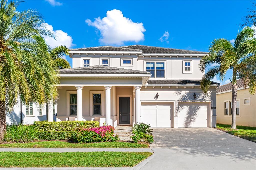 A two-story house with a covered front porch, white columns, and a paved driveway — 15625 SYLVESTER PALM DRIVE, WINTER GARDEN, FL