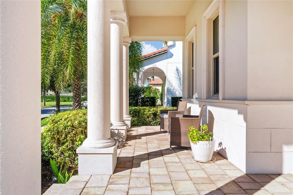 A living room features a grey sofa, a wooden media console, and a large potted plant — 15625 SYLVESTER PALM DRIVE, WINTER GARDEN, FL